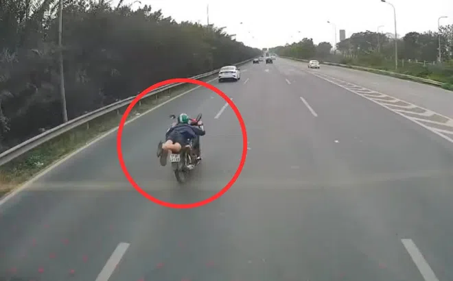 Tài xế ‘làm xiếc’, vừa nằm vừa lái xe máy trên Đại lộ Thăng Long sẽ bị xử lý như thế nào?